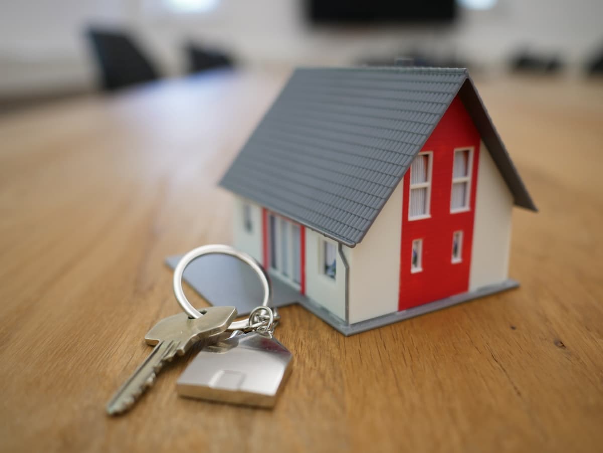 House keys next to a miniature house model